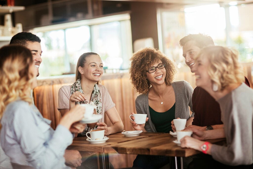 Meeting im Kaffeehaus, Menschen, ausgelassen mit Kaffeetasse in der Hand